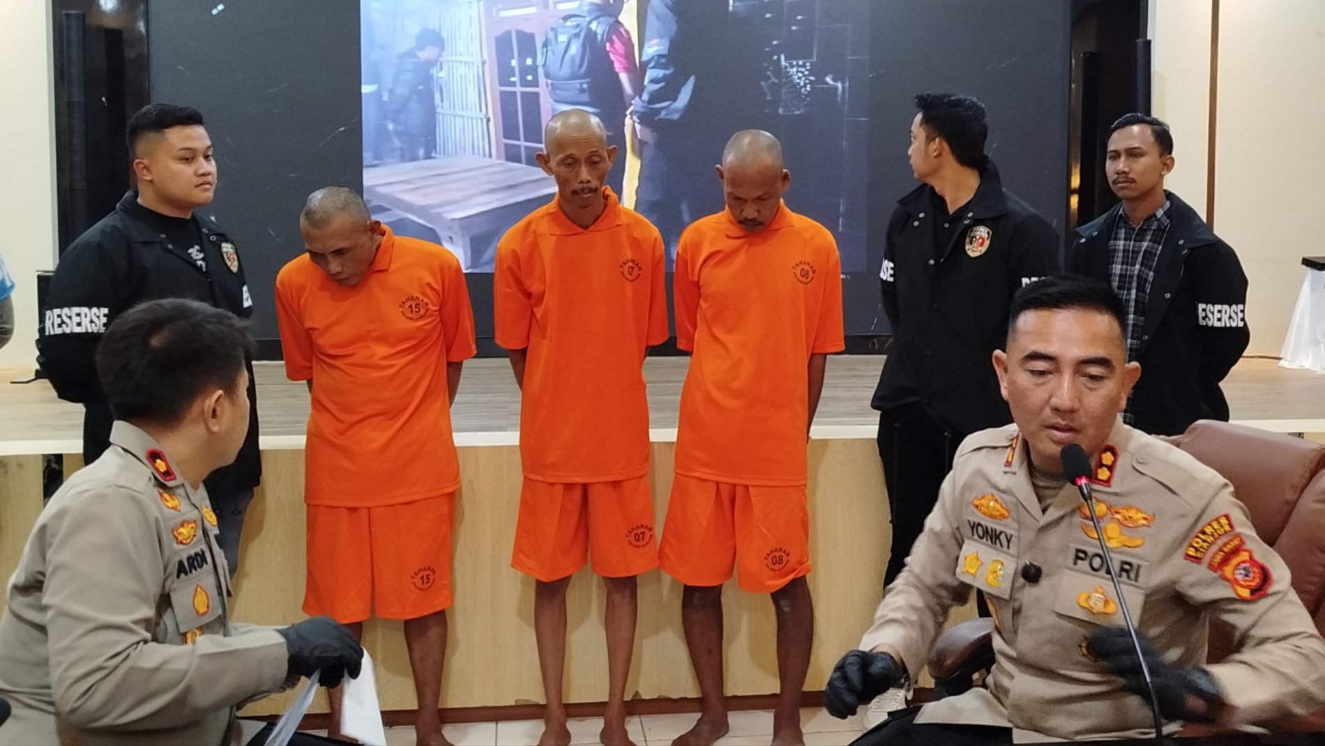 Tersangka pencurian dan penadahan emas di Sindangbarang berdiri mengenakan pakaian tahanan oranye saat konferensi pers Polres Cianjur.