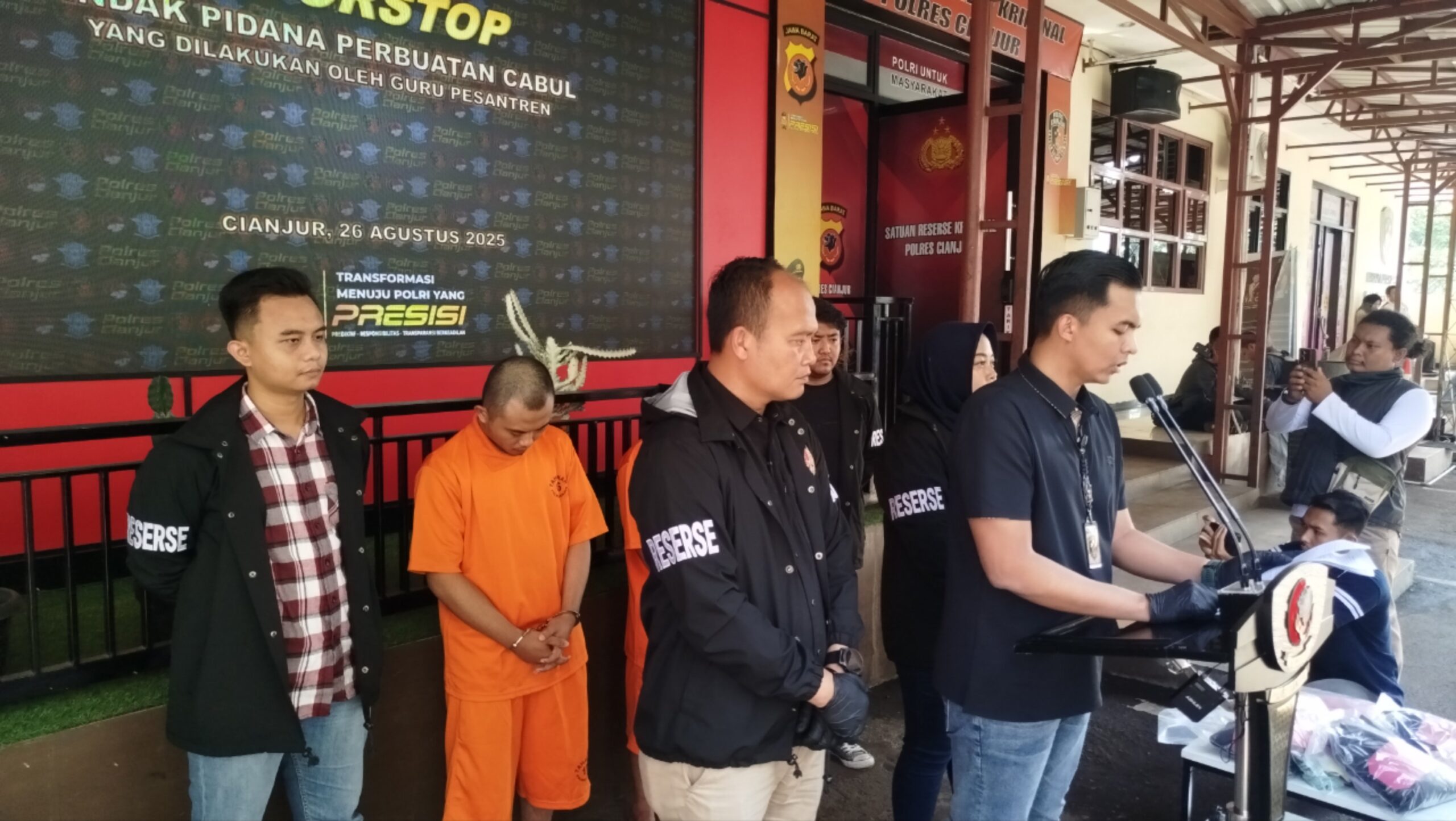 Konferensi pers Polres Cianjur ungkap kasus guru pesantren cabuli anak di bawah umur, tersangka ditampilkan dengan baju tahanan oranye.