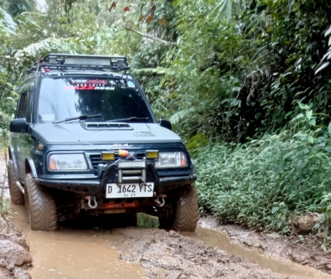Mobil kesulitan melewati jalan rusak parah di Desa Sukamulya, Naringgul, Cianjur.