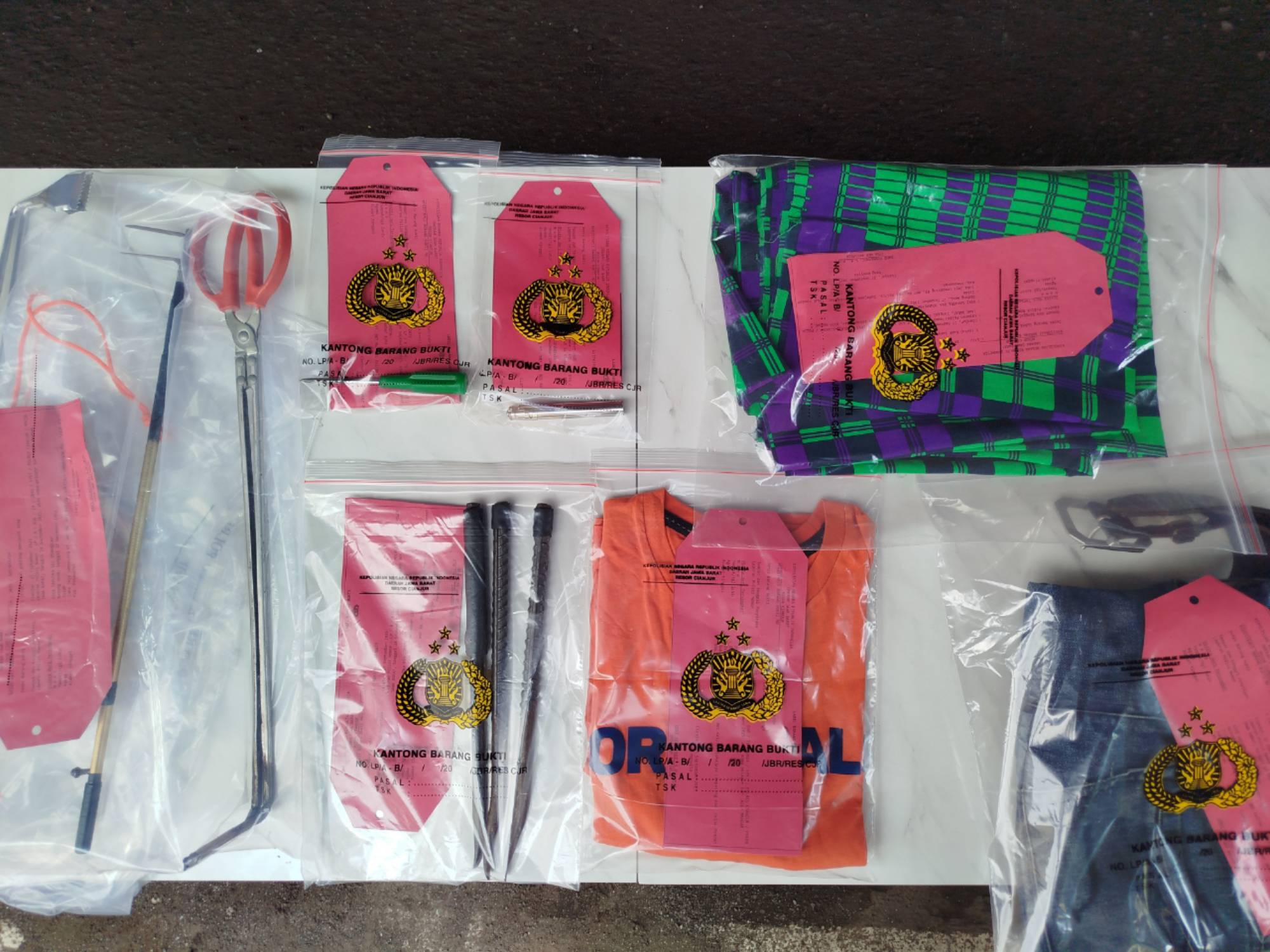 Barang bukti kasus pencurian mobil di Cianjur, termasuk alat perkakas dan pakaian tersangka yang disita polisi.