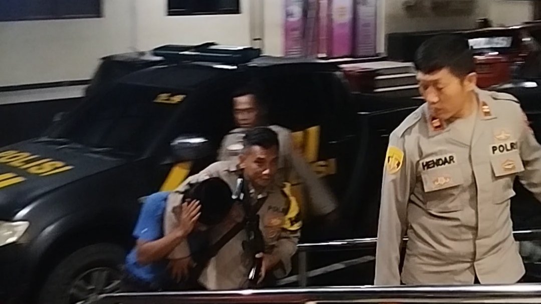 Teks: Polisi membawa terduga pelaku pengeroyokan warga pelapor kasus pupuk bersubsidi di Sukaluyu ke Mapolres Cianjur untuk pemeriksaan lebih lanjut.