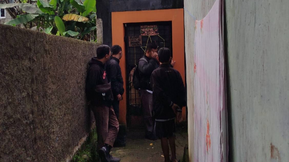 Teks: Sejumlah awak media dan warga berdiri di depan pintu rumah di Cijedil yang dilaporkan mengeluarkan bau gas dan panas tidak wajar.