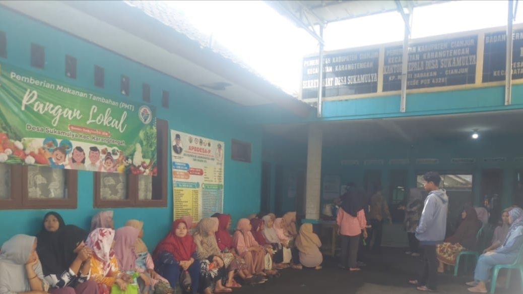 Teks: Petugas desa dan Linmas mengatur antrean warga penerima bantuan pangan di Sukamulya.