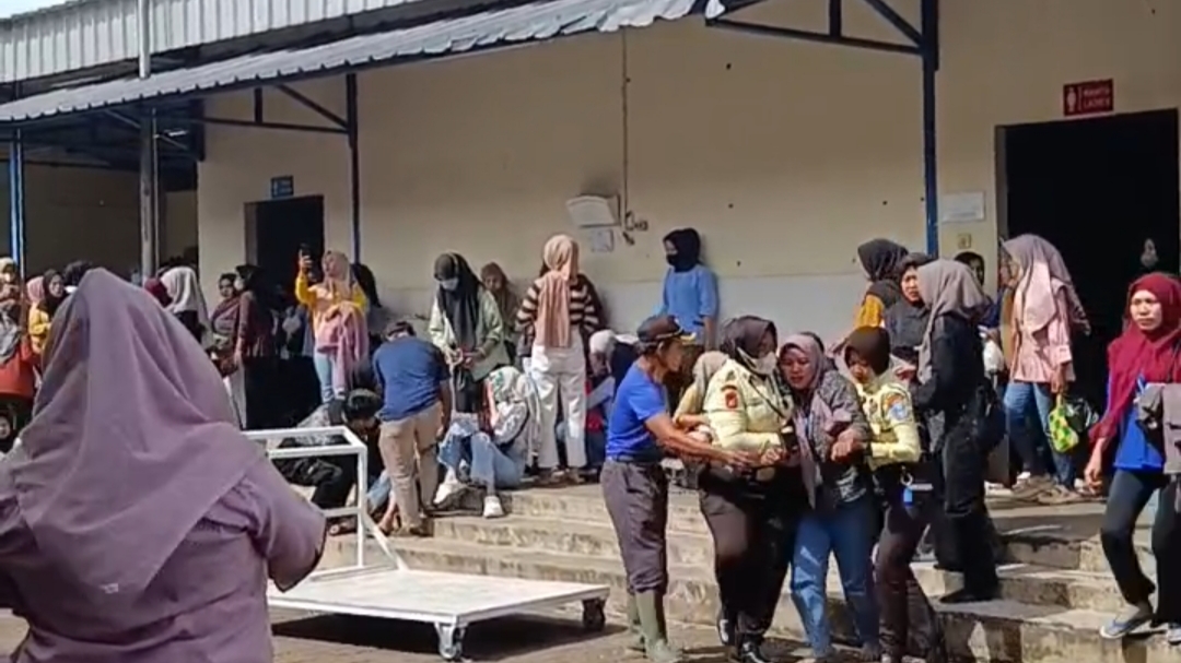 Teks: Evakuasi karyawan kesurupan di PT Aurora World Cianjur saat puluhan pekerja panik dan keluar gedung.