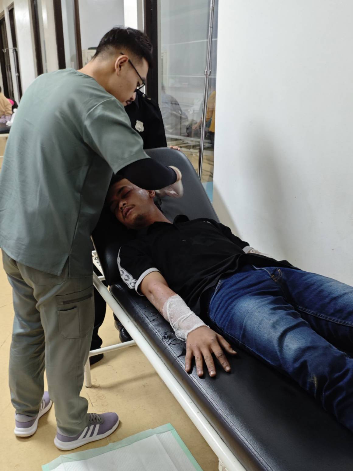 Teks: Petugas medis merawat pengemudi minibus yang mengalami luka bakar ringan setelah kebakaran kendaraan di RSUD Cimacan.