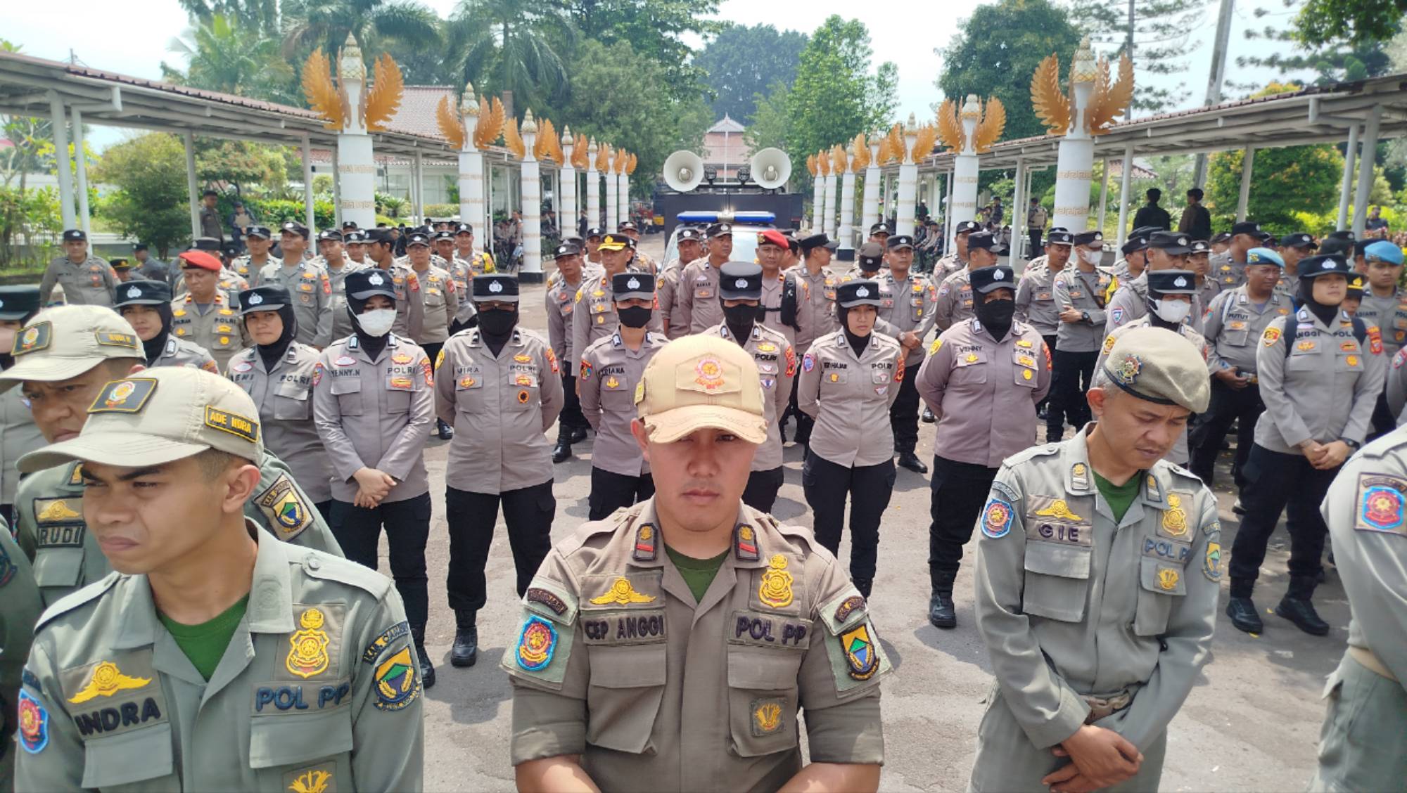 Teks: Aparat kepolisian dan Satpol PP berbaris menjaga Pendopo Cianjur saat warga melakukan aksi menolak proyek geothermal.