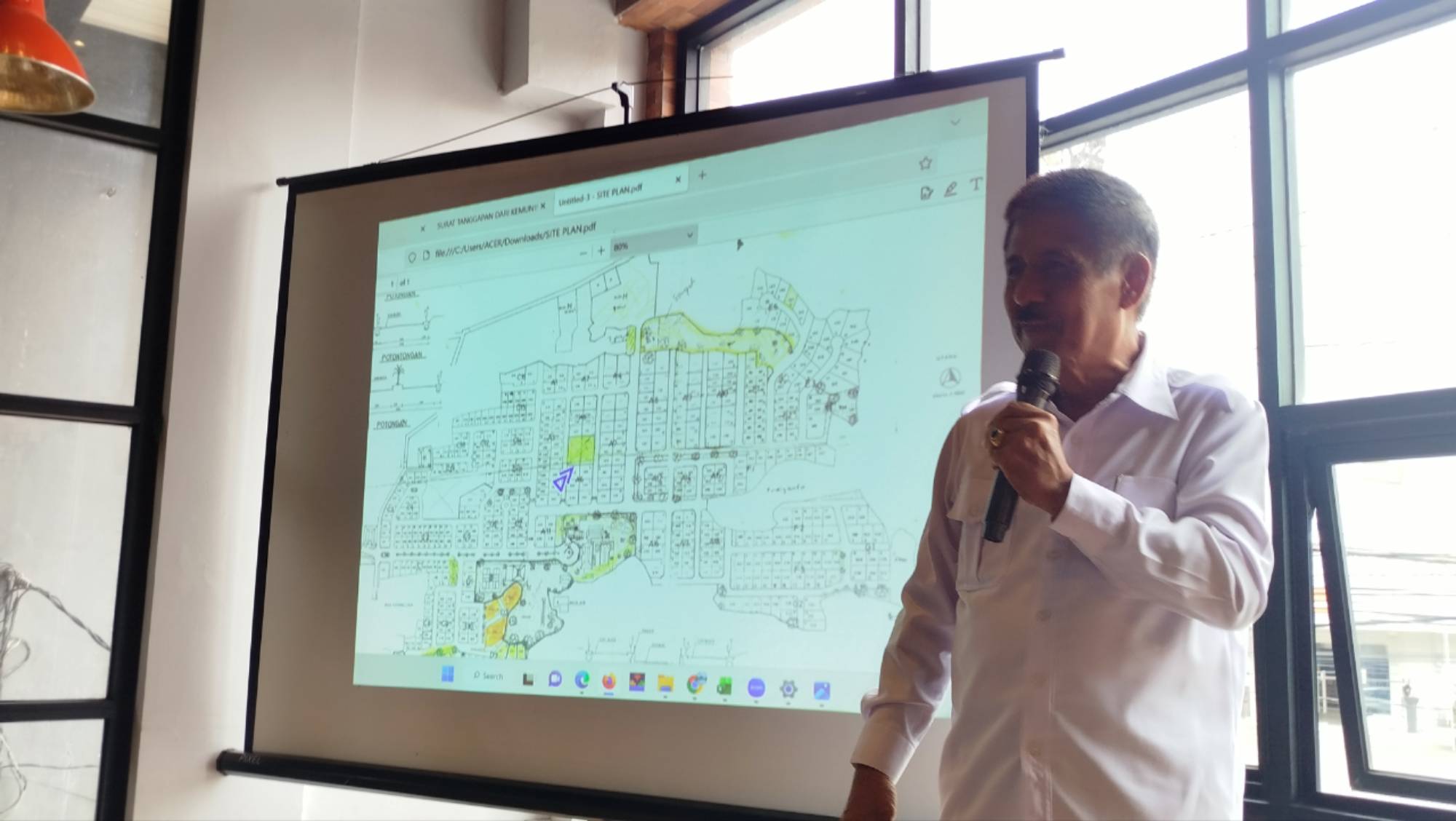 Teks: Agus Anwar memperlihatkan denah Villa Green Hill yang menyoroti dugaan penjualan fasos dan fasum kepada pihak hotel di kawasan Green Hill Pacet, Cianjur.