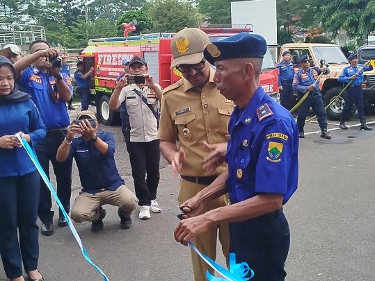 Teks: Prosesi pengguntingan pita penyambutan mobil pemadam kebakaran hibah Pemprov DKI Jakarta di Pendopo Pemda Kabupaten Cianjur.