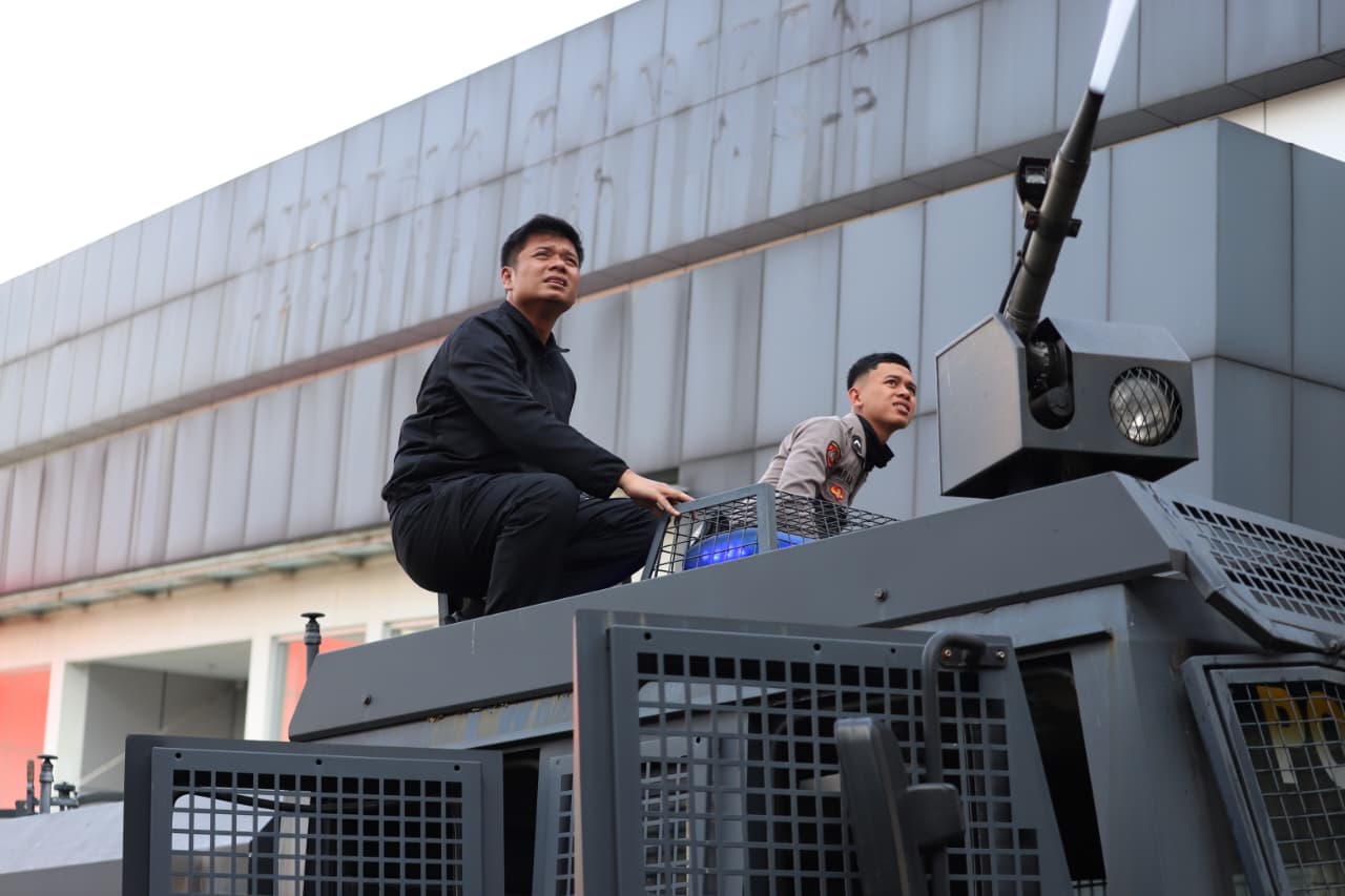 Teks: Kapolres Cianjur AKBP Akhmad Alexander Yurikho Hadi membantu petugas damkar memadamkan api kebakaran Toko Serbaguna Sanya di Cianjur, Sabtu 24 Januari 2026.