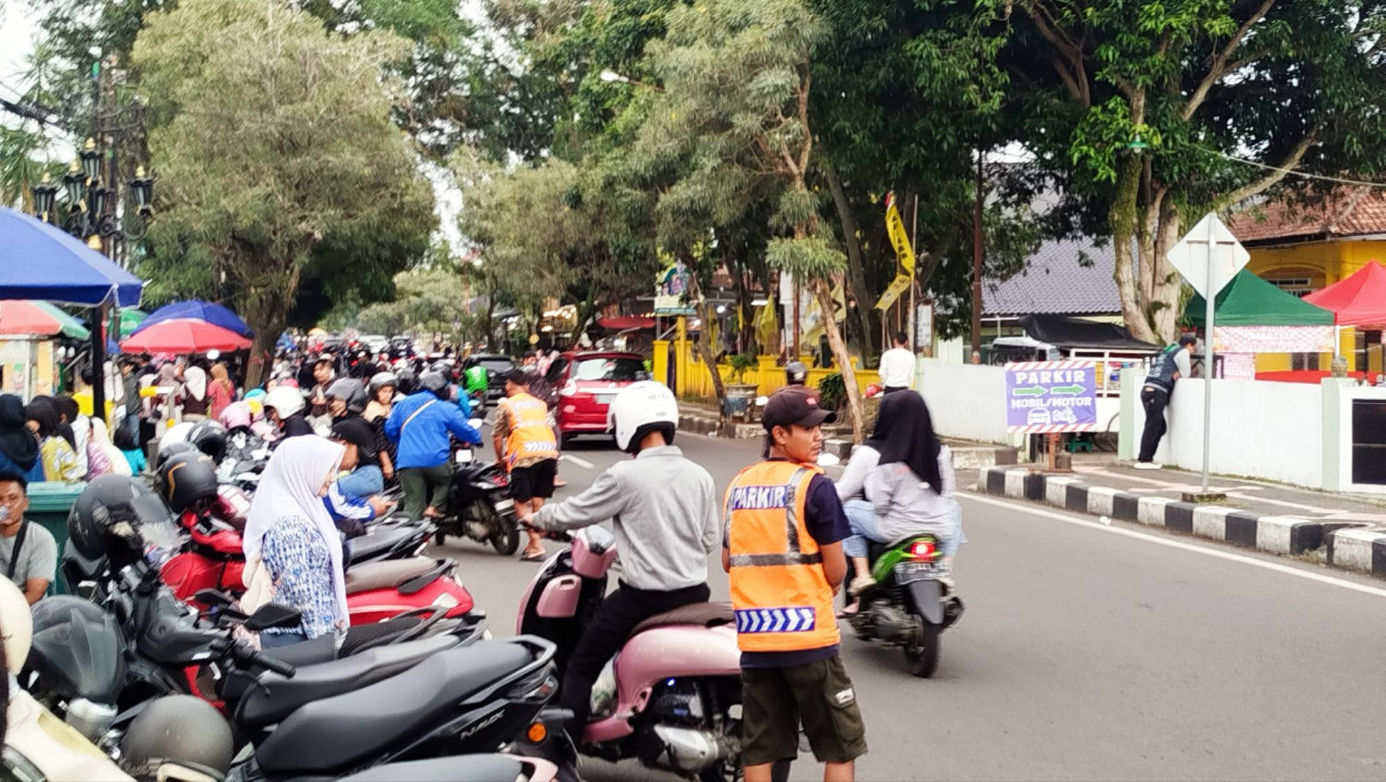 Teks: Aktivitas parkir di area jajanan Gereja St. Petrus Cianjur