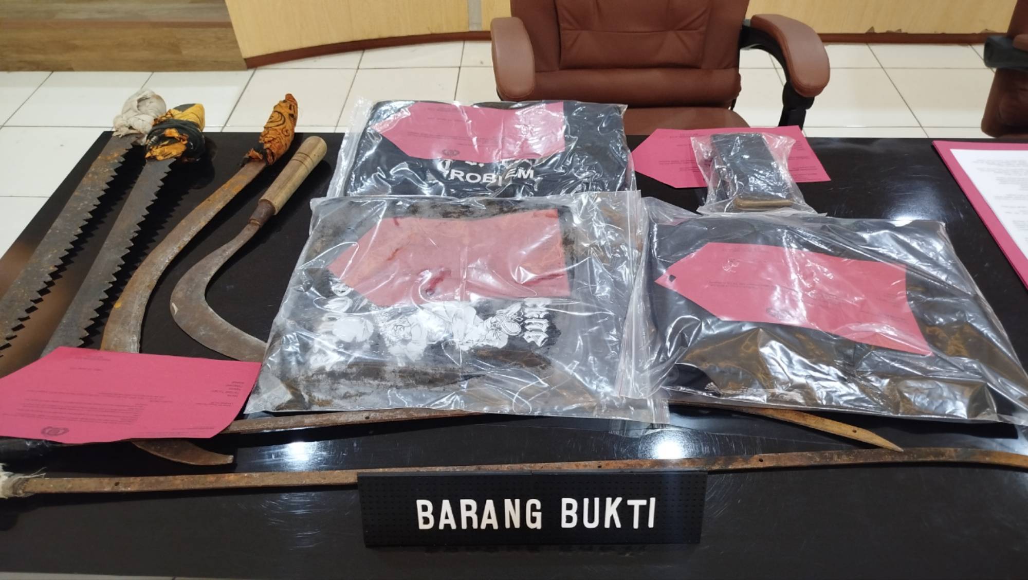 Teks: Barang bukti kasus dugaan pengeroyokan di Sukaluyu ditampilkan saat press release Polres Cianjur di Aula Mapolres Cianjur, 26 Januari 2026.