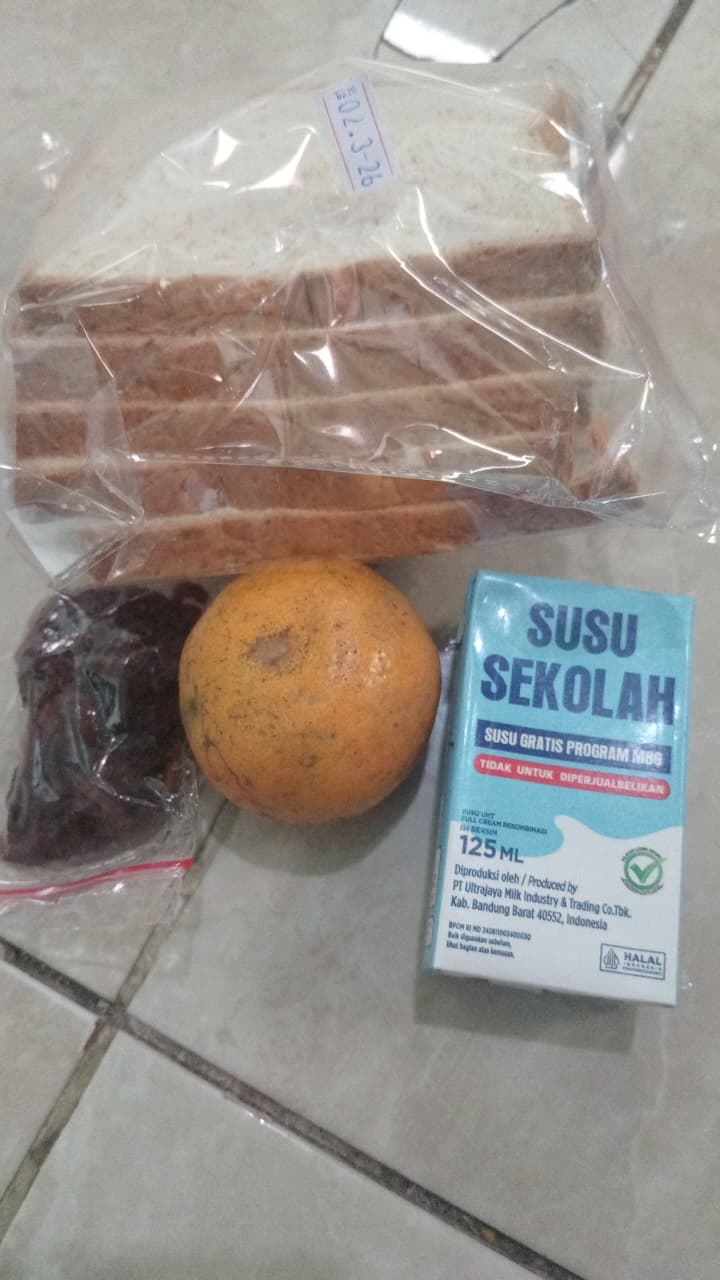 Teks: Paket MBG Cugenang berisi susu 125 ml, jeruk, roti tawar dan abon.