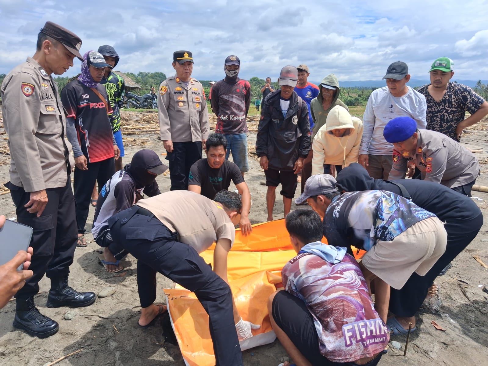 Teks: Petugas mengevakuasi korban laka laut Cidaun yang ditemukan di pinggir pantai muara Cidamar.