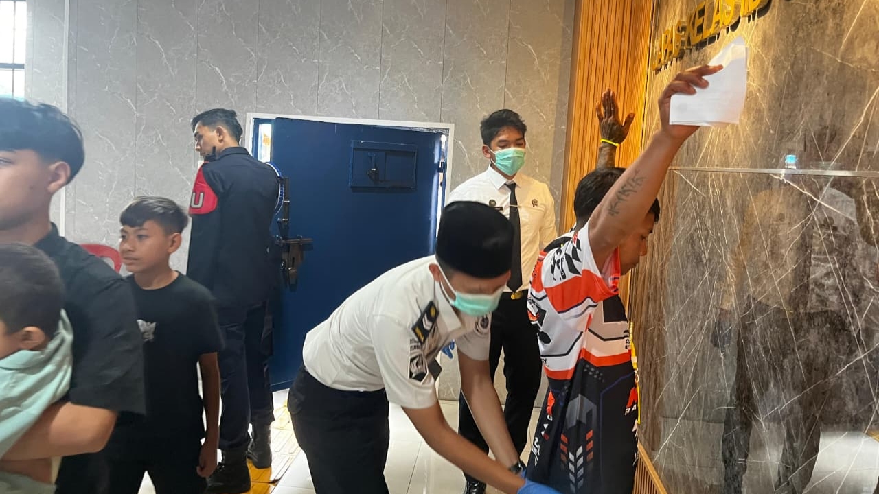 Teks: Petugas Lapas Cianjur memeriksa pengunjung saat layanan kunjungan 