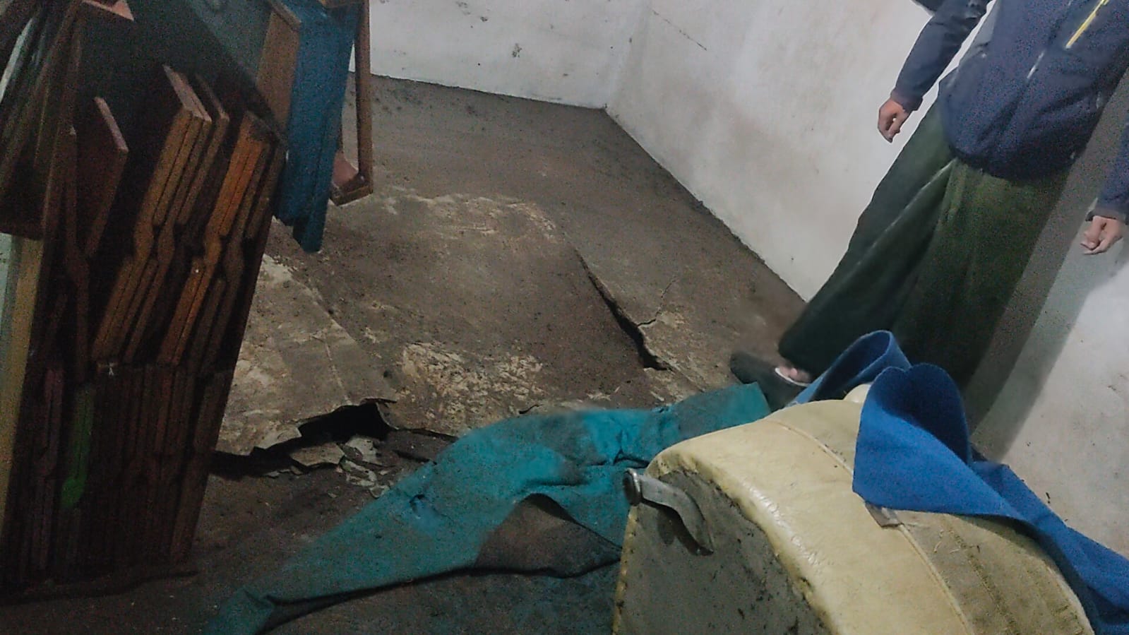 Teks: Lantai madrasah di Cianjur jebol dan retak akibat banjir yang merendam bangunan saat hujan deras