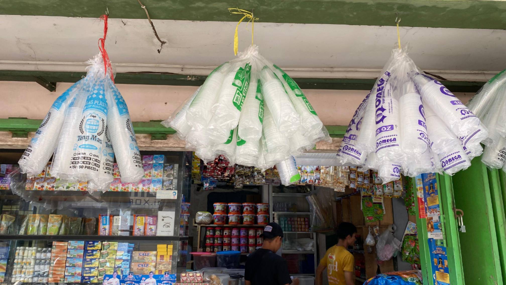 Teks: Gelas plastik berbagai ukuran dijual di kios Pasar Induk Cianjur saat harga plastik mengalami kenaikan