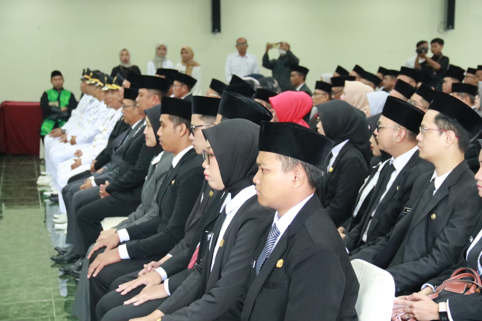 Teks: Pelantikan pejabat Pemerintah Kabupaten Cianjur oleh Bupati Cianjur di sebuah gedung acara.