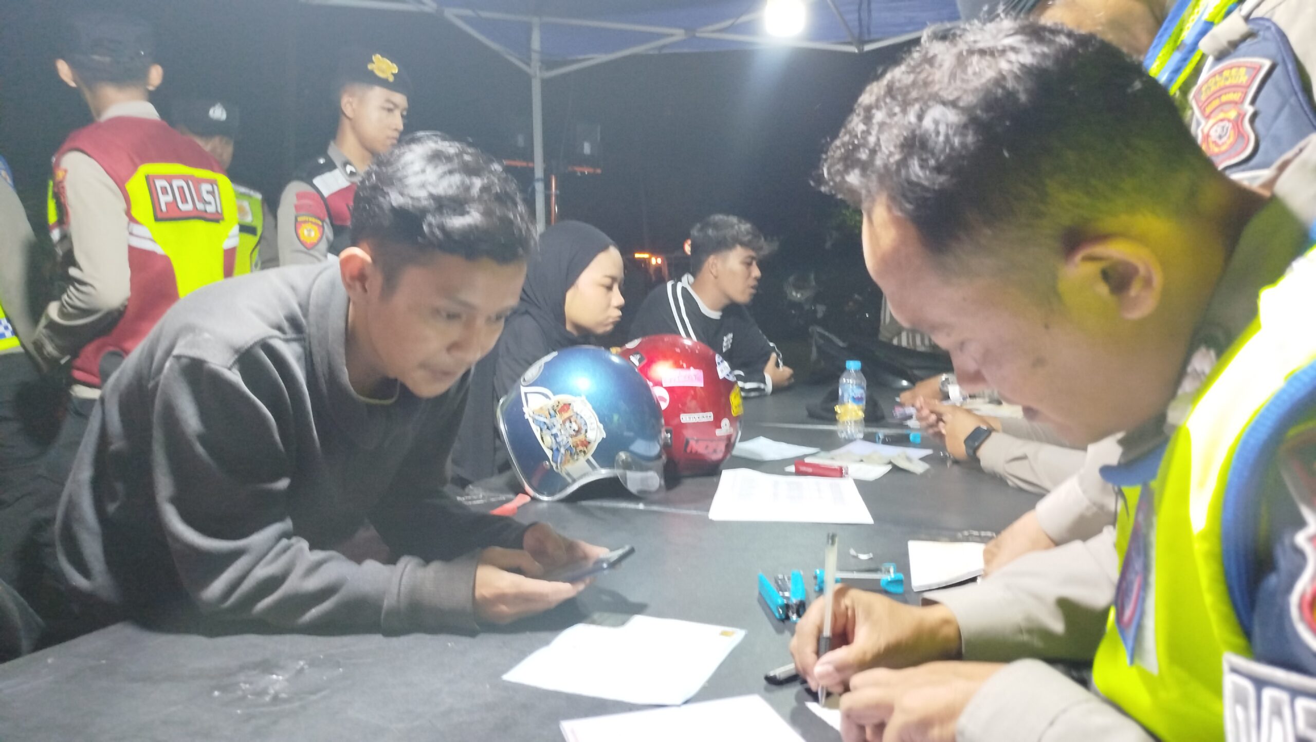 Teks: Petugas polisi mendata pengendara saat razia knalpot brong di Cianjur