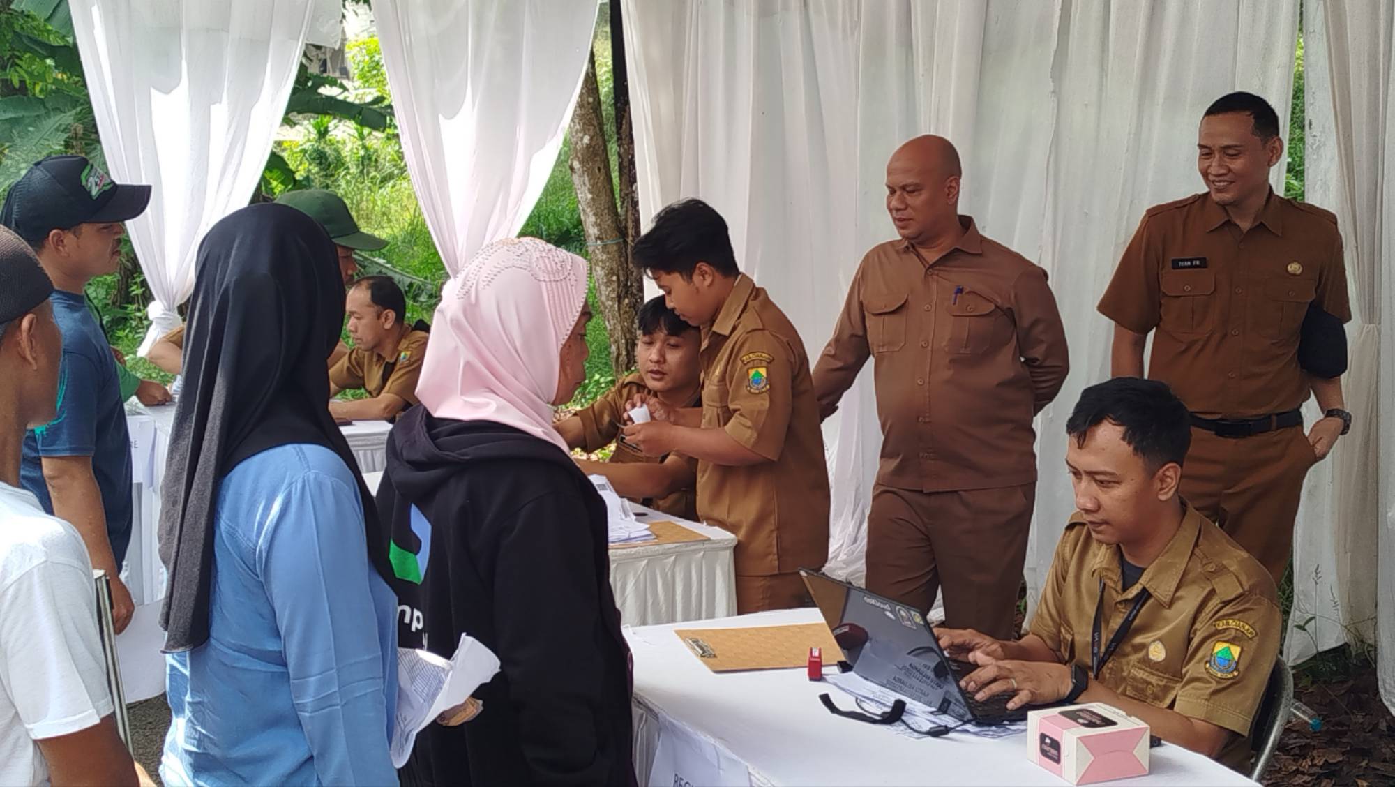 Teks: Antrean warga dalam kegiatan pasar murah Gekbrong oleh Pertamina di Cianjur