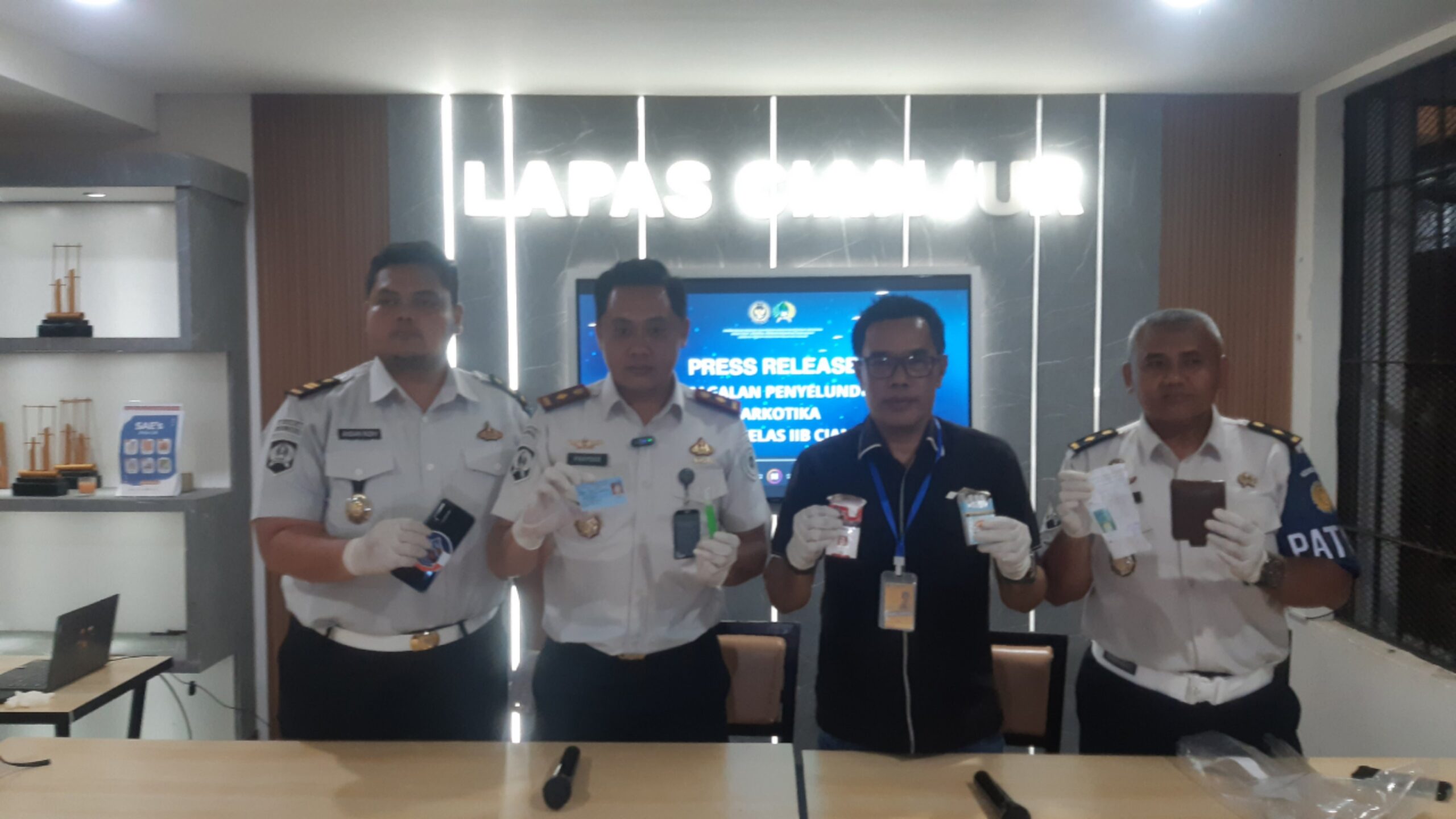 Teks: Petugas menunjukkan barang bukti dugaan spray sintetis dan KTP palsu di Lapas Cianjur.