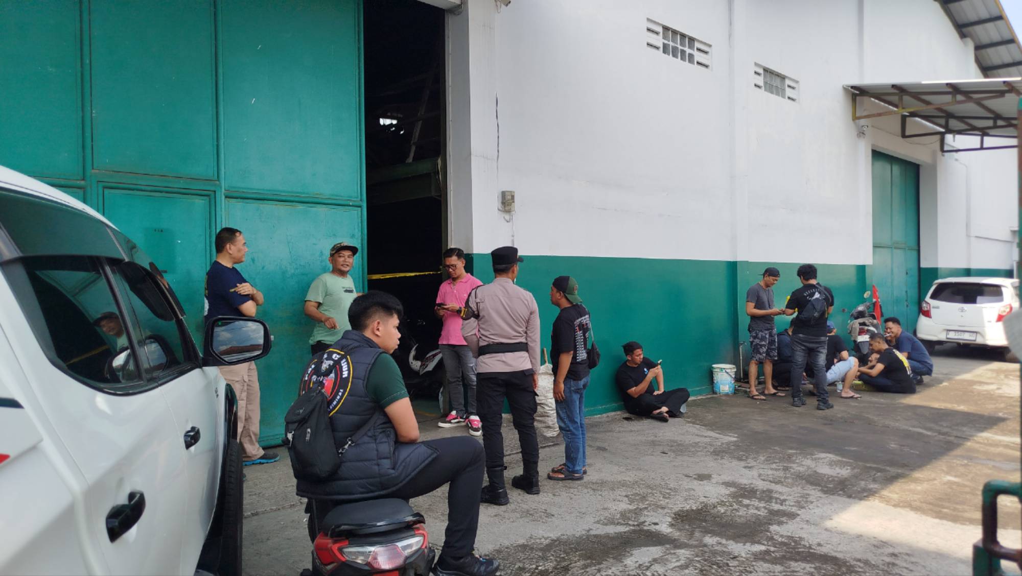 Teks: Lokasi pembunuhan di gudang motor Honda Cianjur dengan garis polisi terpasang