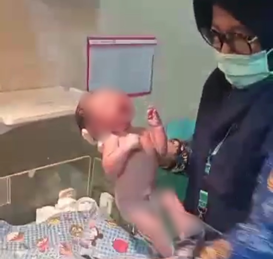 Teks: Tenaga medis memeriksa bayi laki-laki yang ditemukan di dalam karung di area persawahan Kecamatan Cilaku, Cianjur.