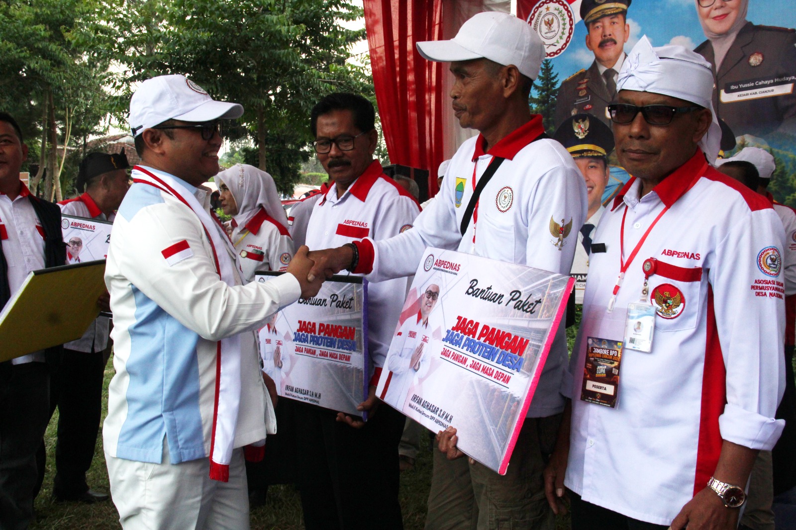 Teks: Irfan Aghasar dari DPP ABPEDNAS menyerahkan bantuan simbolis pada kegiatan Jambore BPD Cianjur 2026 di Pacet.