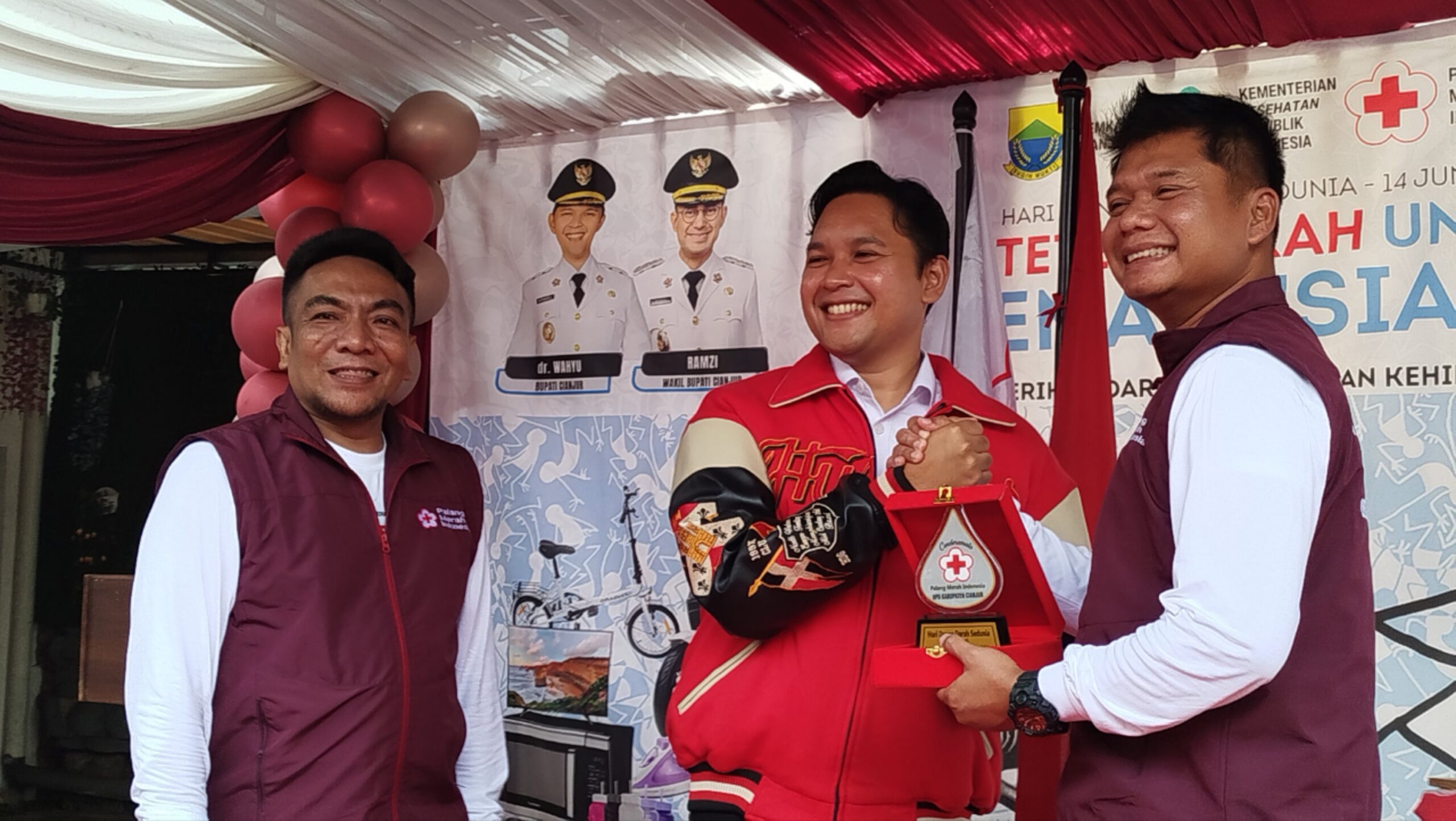 Teks:Bupati Cianjur menyerahkan plakat penghargaan kepada Kapolres Cianjur pada peringatan Hari Donor Darah Sedunia.
