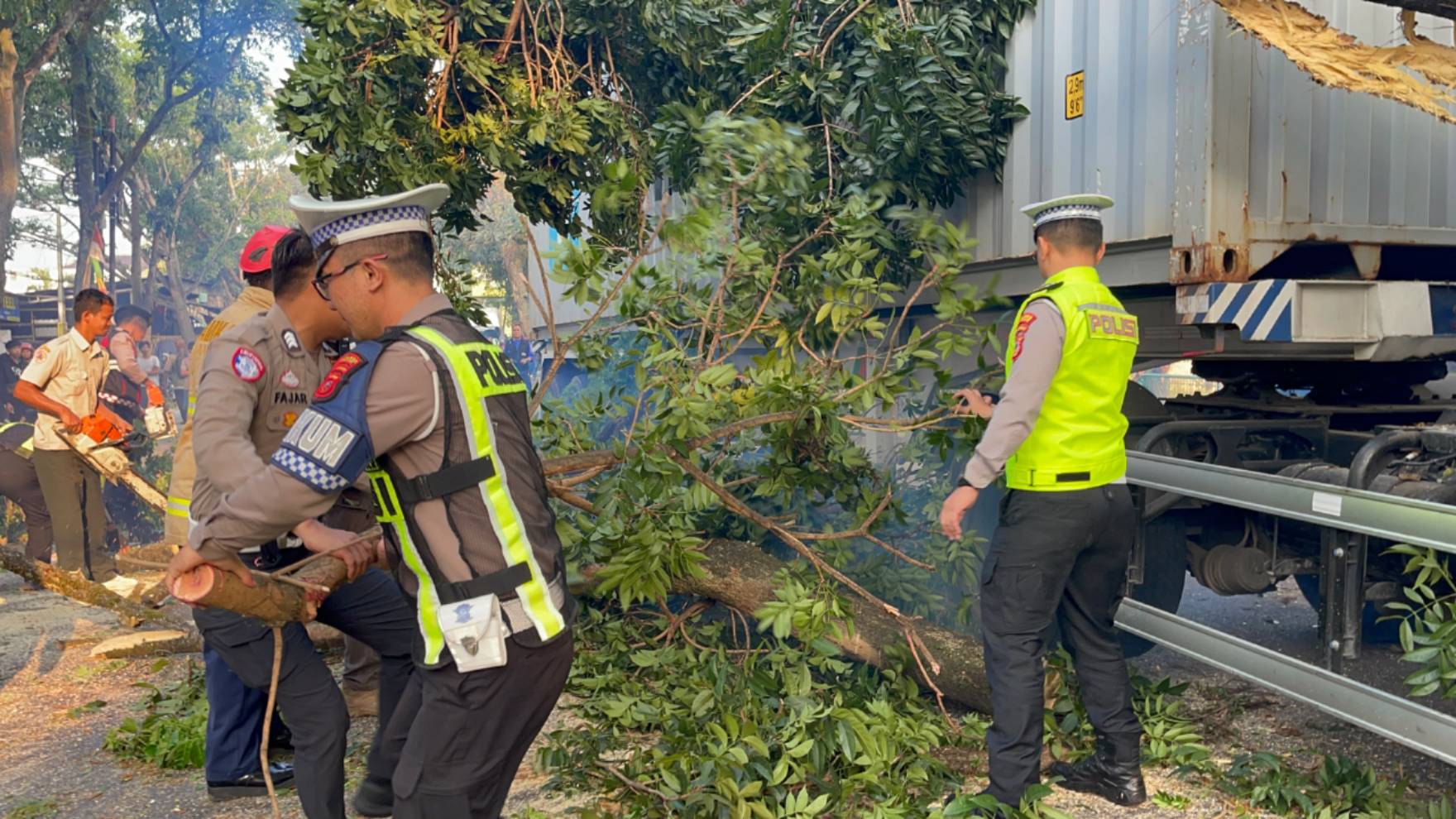 Teks: Evakuasi pohon tumbang akibat kontainer tabrak pohon di Jalan Raya Bandung, Cianjur.