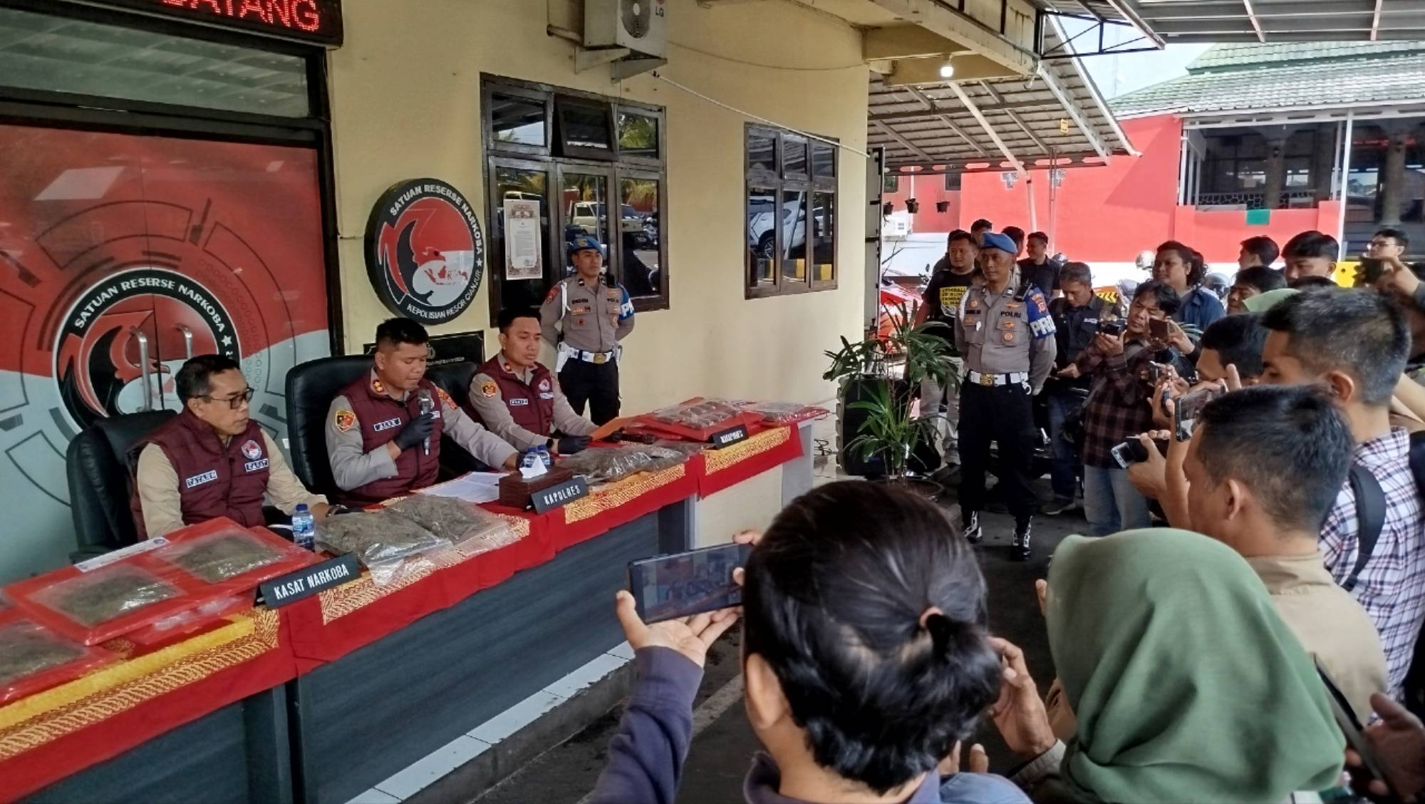 Teks: Kapolres Cianjur menunjukkan barang bukti 14,819 kilogram ganja saat konferensi pers pengungkapan kasus narkotika di Mapolres Cianjur, Selasa (21/7/2026).