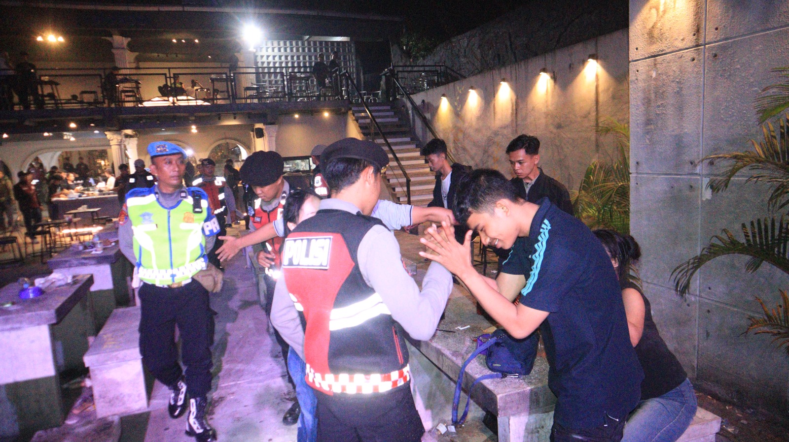 Teks: Petugas Polres Cianjur memeriksa pengunjung kafe saat razia gabungan pencegahan peredaran narkotika di Kabupaten Cianjur.