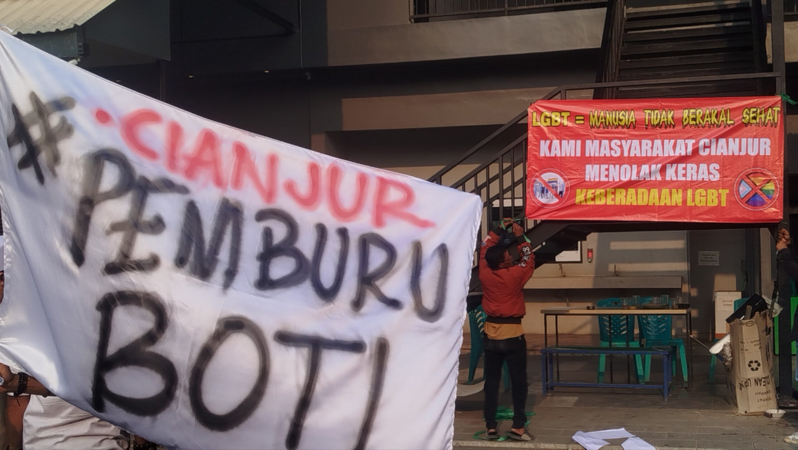 Teks: Massa aksi tolak LGBT memasang banner di depan salah satu kafe di Cianjur.