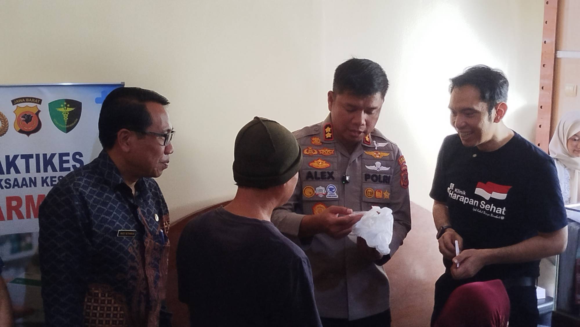 Teks: Kapolres Cianjur dan dr. Yusuf Nugraha melayani masyarakat dalam program pengobatan gratis.