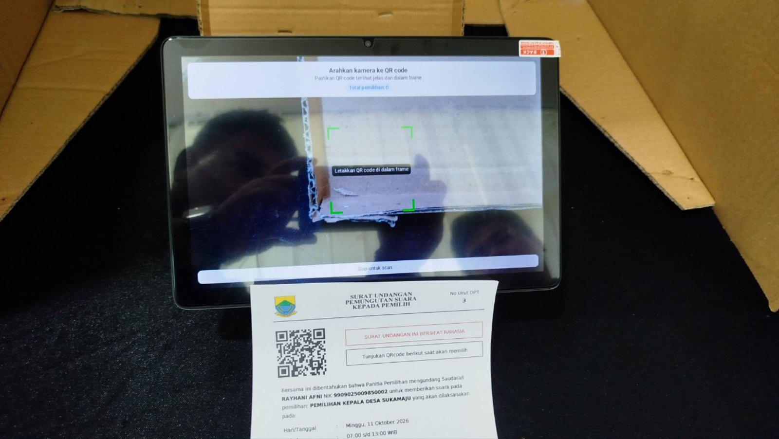 Teks: Simulasi Pilkades digital Cianjur menggunakan tablet dan QR code untuk pemungutan suara.