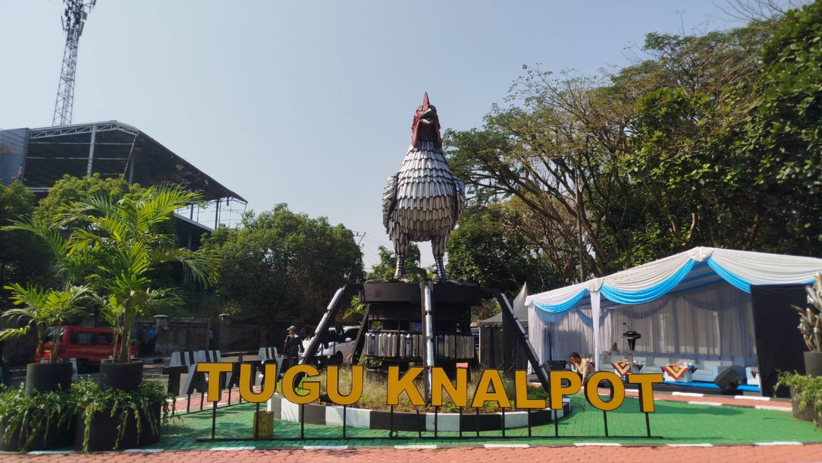 Teks: Tugu Knalpot Ayam Pelung di Jalan Dr. Muwardi, Cianjur, yang menjadi ikon dan simbol kampanye tertib berlalu lintas.