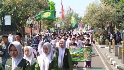 Teks: Pawai Hari Santri Nasional 2026 di Cianjur diikuti santri dan pelajar dengan membawa bendera serta spanduk pesantren.